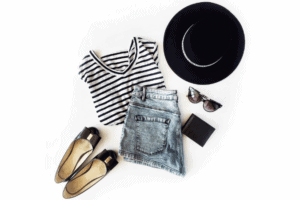 An overlay of a woman's outfit with a black hat, shoes a stripped black and white tee shirt and jeans with accessories 