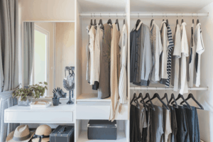 A white closet filled with an elegant wardrobe of matching clothes and very organized