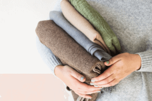 Woman holding a neatly folded sweaters