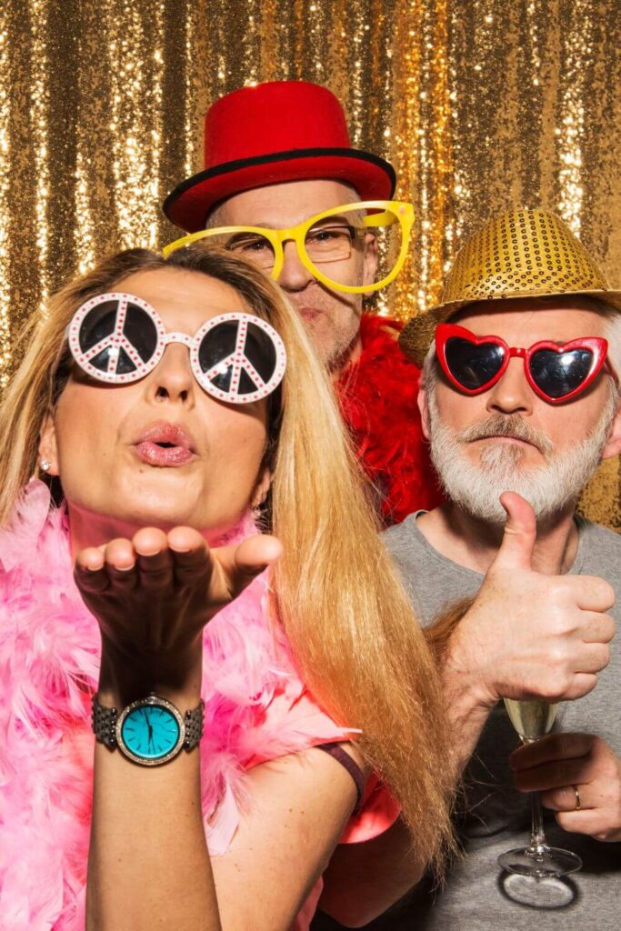 Three people playing dress up at a Photo Booth at a birthday party