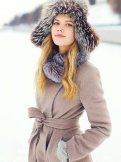 Winter Fashion: An elegant woman standing with a winter coat and a beautiful faux fur hat