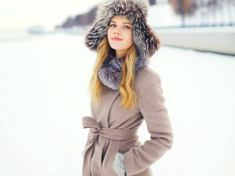 Winter Fashion: An elegant woman standing with a winter coat and a beautiful faux fur hat