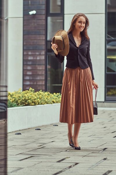 Casual Old Money Summer Outfit: A woman wearing a pleated brown skirt